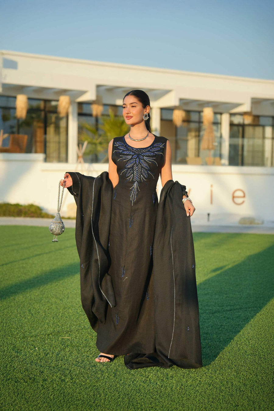 Elegant black abaya with delicate detailing layered over a shimmering silver and navy inner piece, perfect for evening occasions