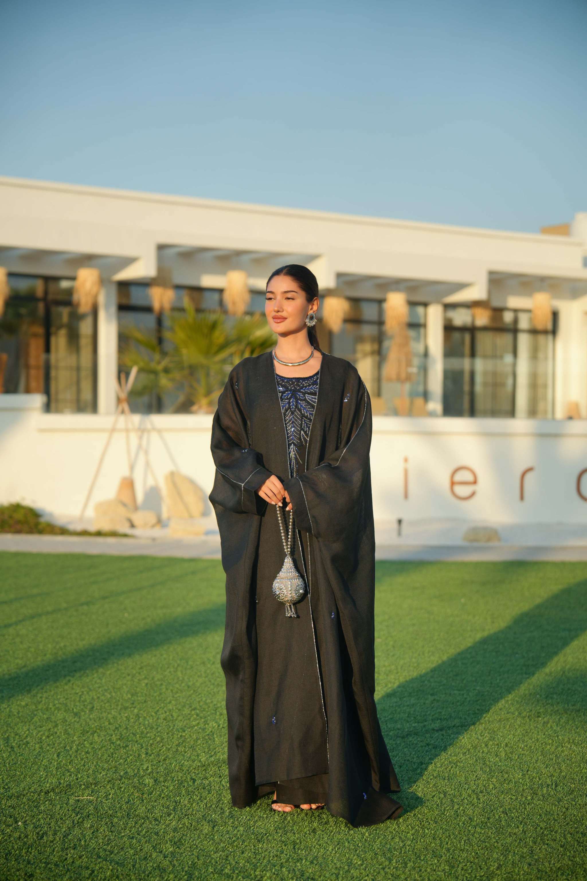 Elegant black abaya with delicate detailing layered over a shimmering silver and navy inner piece, perfect for evening occasions