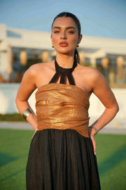 Woman wearing a black khesha bisht with golden touch embroidery paired with a black to golden linen jumpsuit featuring subtle golden details, styled outdoors.