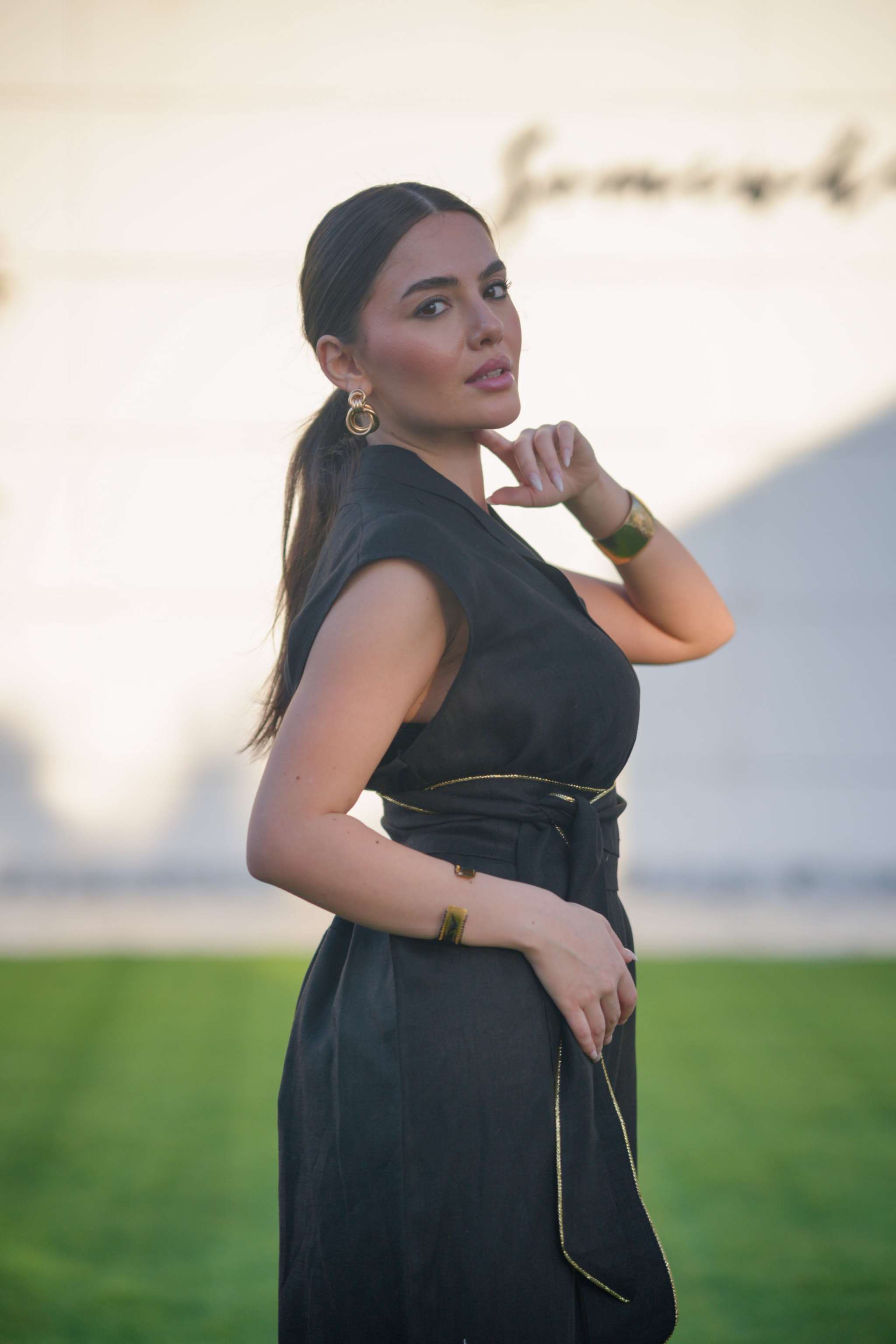 Woman wearing a sleek black linen jumpsuit with cinched waist and wide-leg cut outdoors