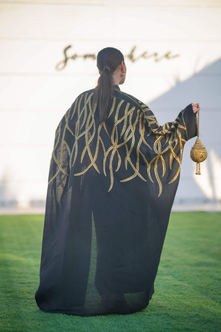 Black linen bisht with bold gold leaf embroidery, wide sleeves, and relaxed open front for elegant layering.