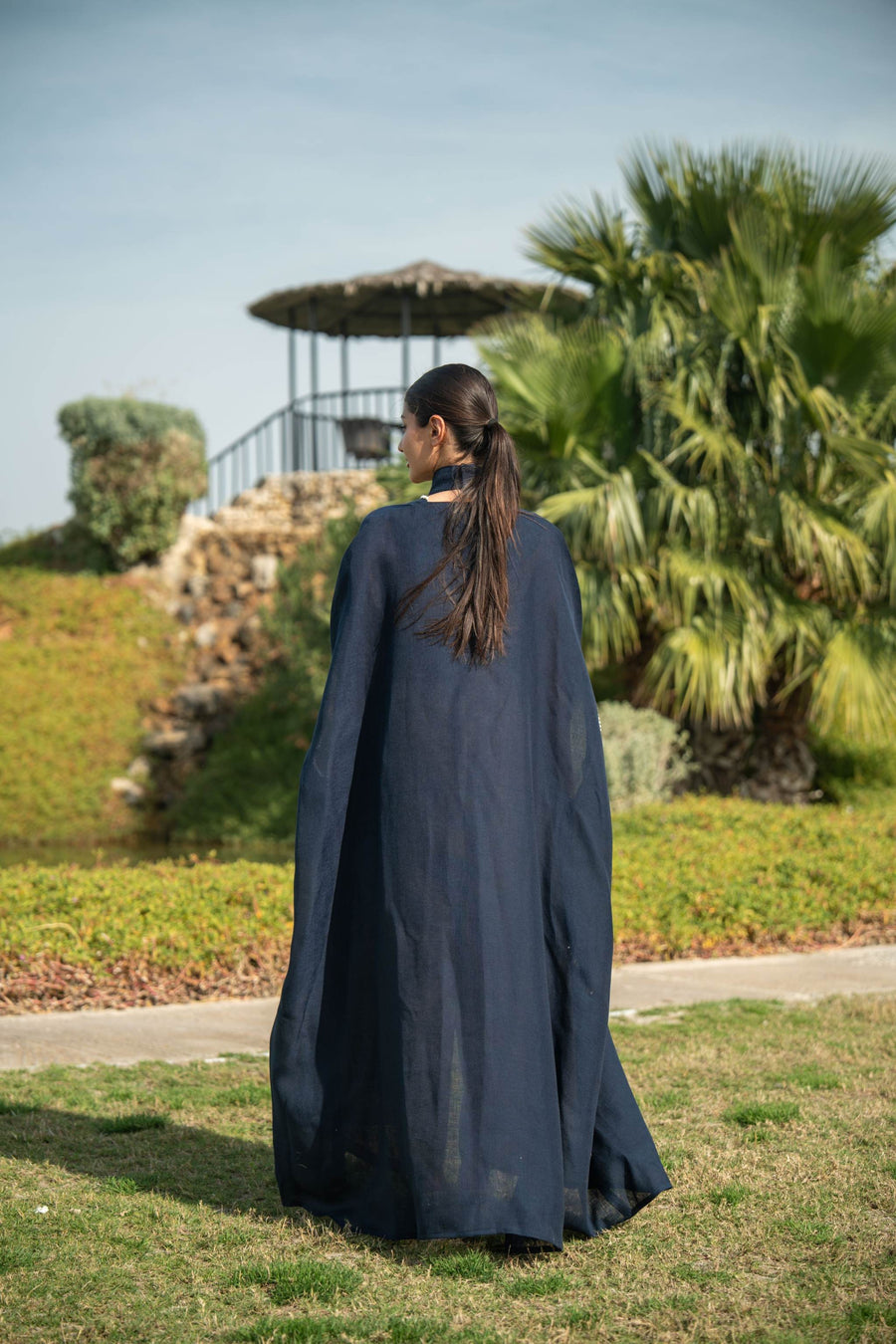 Elegant navy blue bisht with beige lining and delicate piping worn outdoors