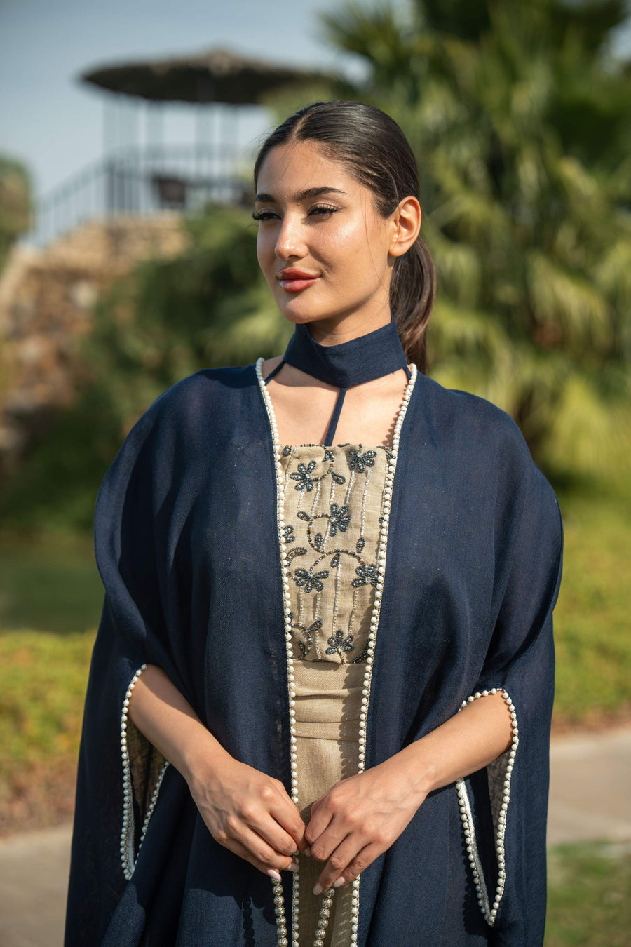 Elegant navy blue bisht with beige lining and delicate piping, featuring a flowing silhouette for day and evening wear