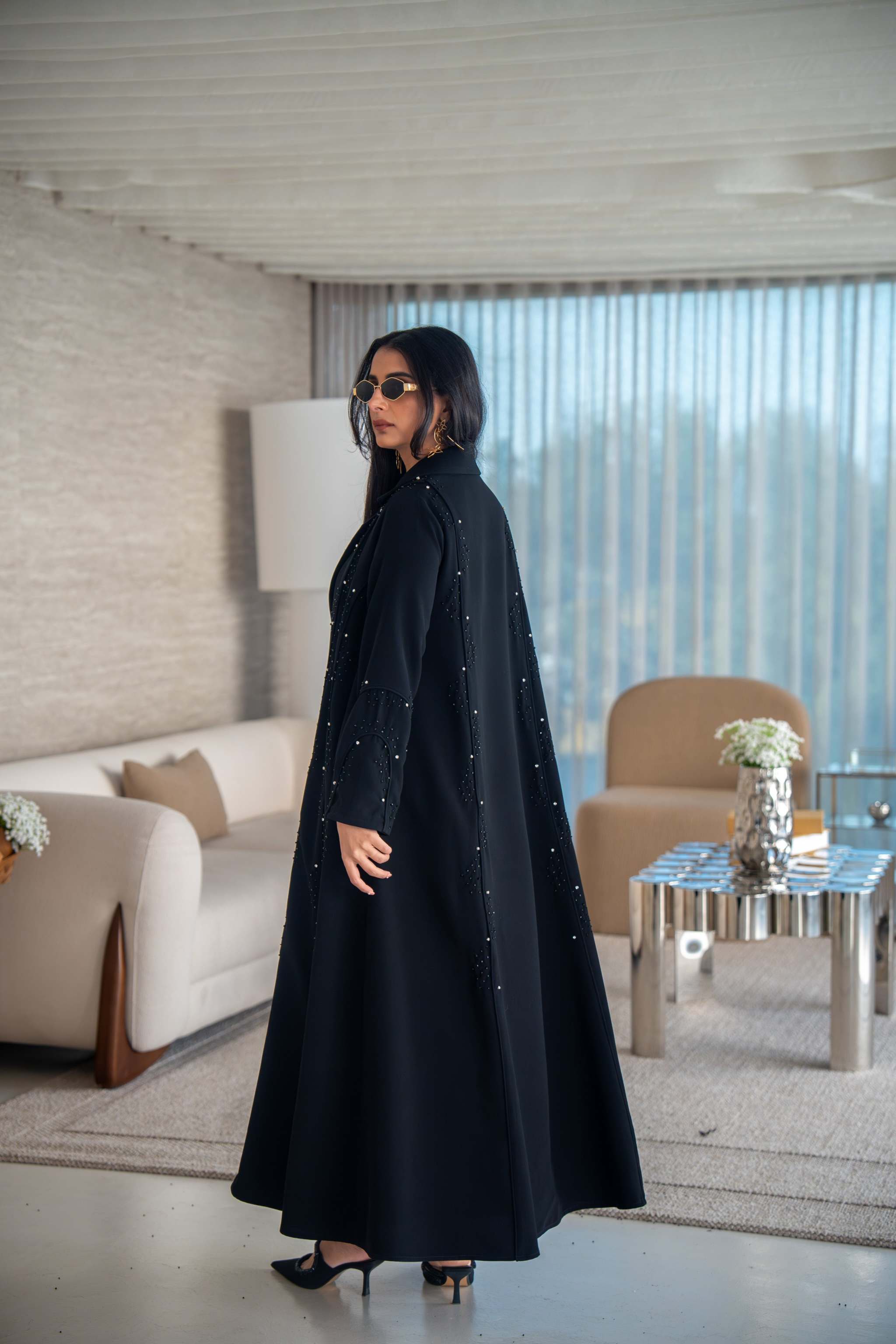 Velira black crepe abaya with delicate dot embroidery and flowing silhouette worn indoors