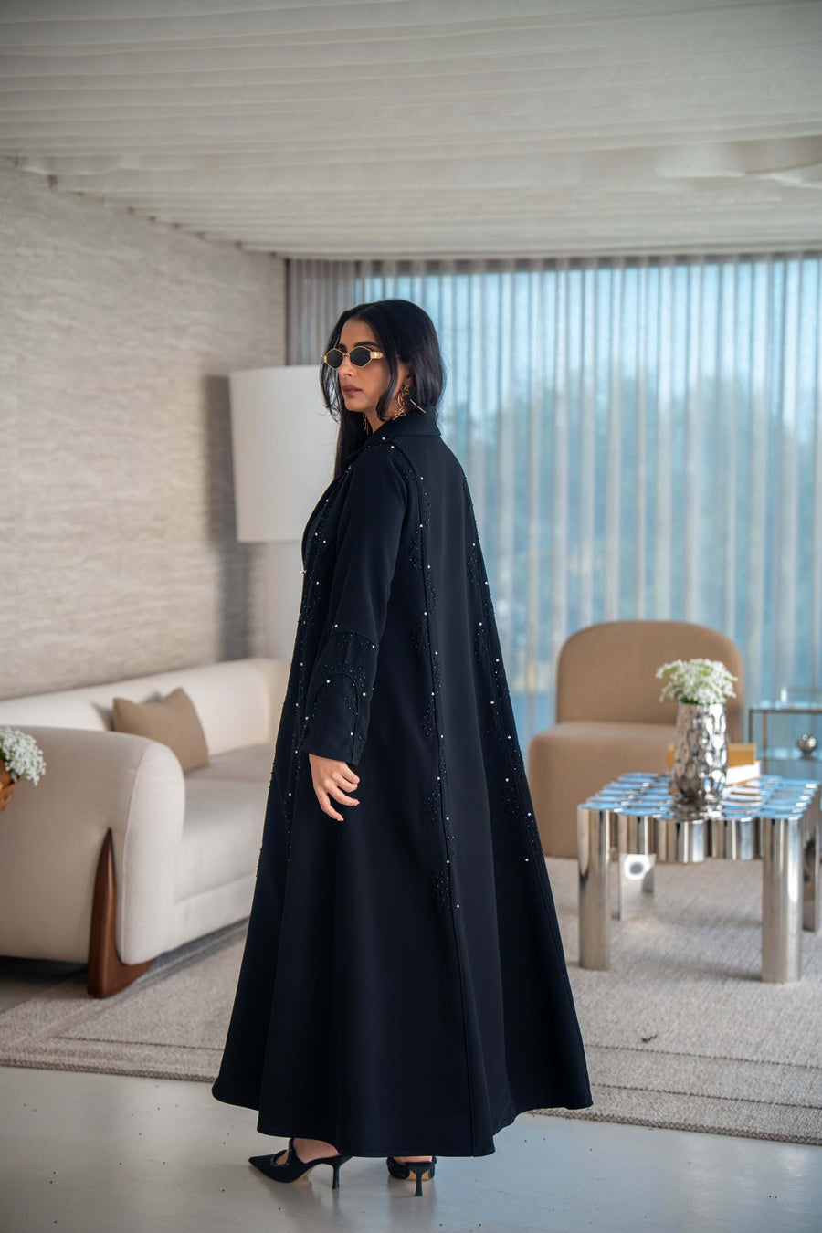 Velira black crepe abaya with delicate dot embroidery and flowing silhouette worn indoors