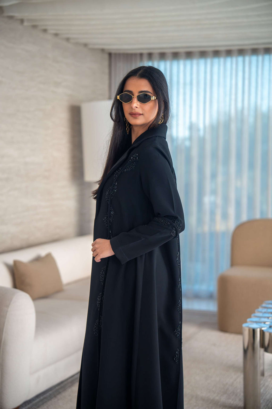 Black crepe abaya with flowing silhouette and lightweight texture modeled indoors