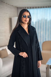 Woman wearing black crepe abaya with flowing silhouette and lightweight texture indoors