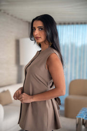 Beige crepe blouse with soft flare cut, hidden button closure, and side pockets for a sleek, minimalist look.