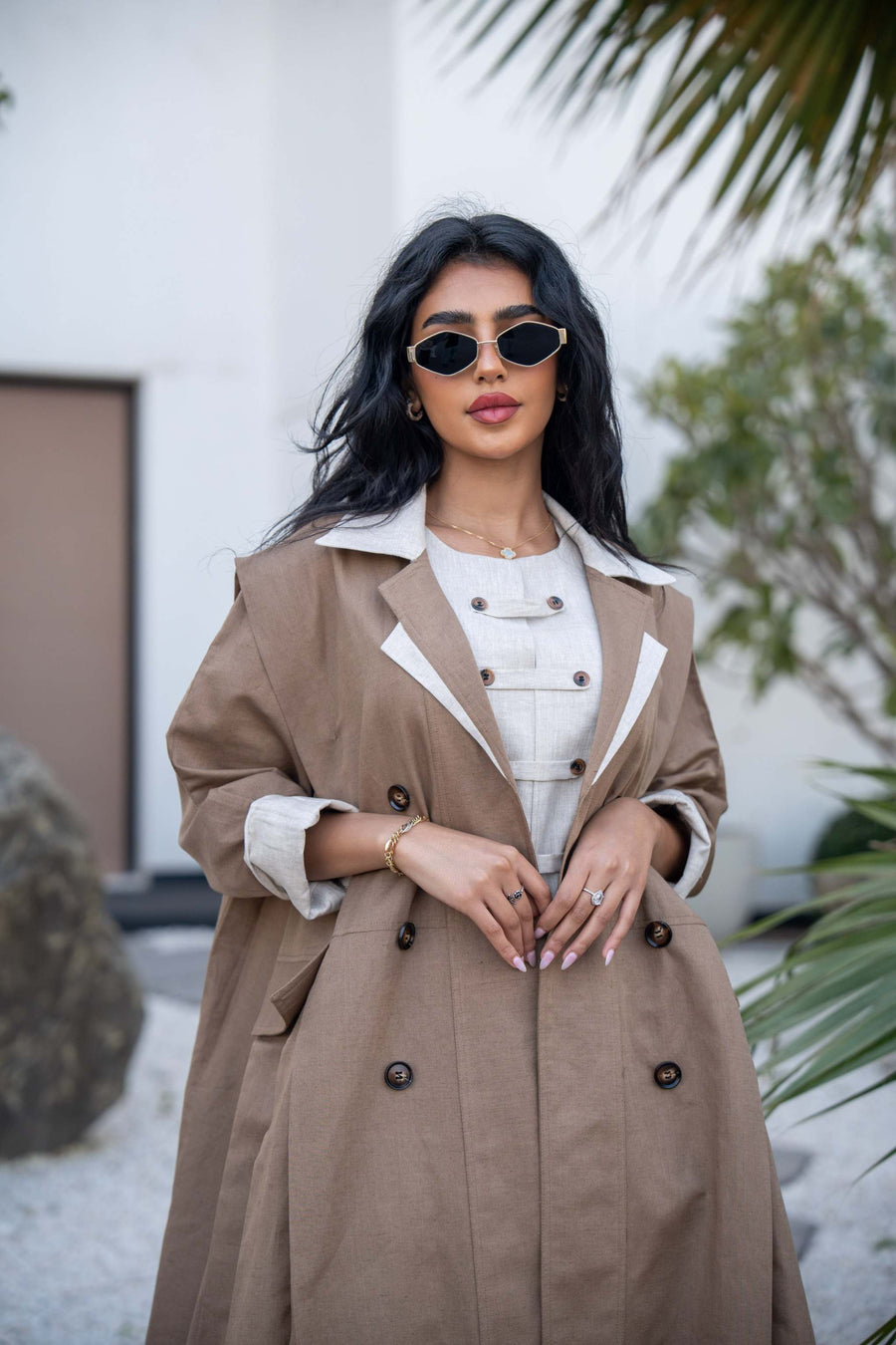 Woman wearing Creme Caramel two-tone mocha brown abaya with off-white lapels and double-breasted design outdoors