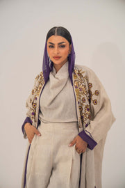 Woman wearing a lightweight linen open-front bisht abaya with gold and purple floral beadwork and purple chiffon lining.