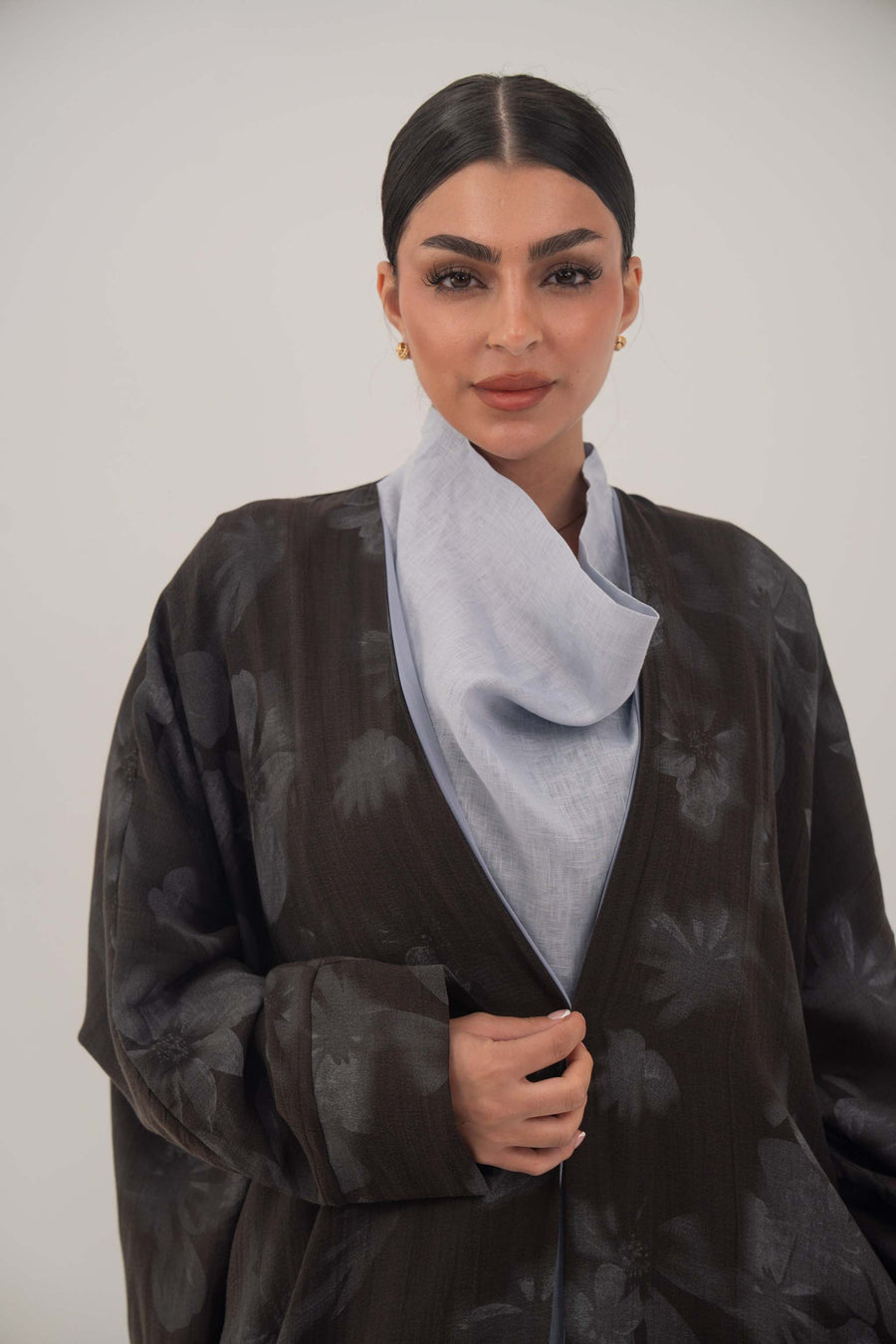 Silk abaya with wide relaxed cut, open front, soft lapel, long sleeves, subtle dark pattern, and soft sheen fabric.
