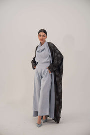 Woman wearing Selva silk abaya with open front, soft lapel, long sleeves, and subtle dark patterned sheen fabric.