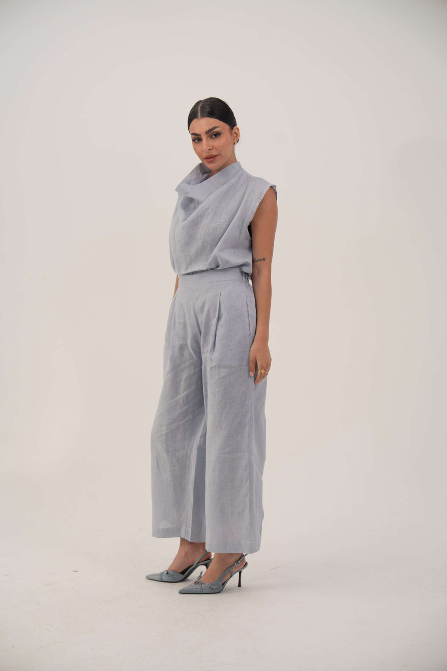 Light blue wide-leg linen pants with high waist and subtle front pleats, cropped above the ankle for a modern look.