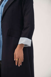 Longline navy linen blend abaya with folded blue pinstripe cuffs and sharp lapels.
