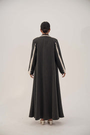 Back view of elegant black pinstriped blazer-style abaya with off-white inner cuffs and shoulder details, full-length and tailored.