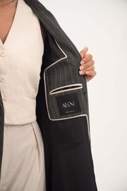 close-up of the inner lining of Ashmood blazer-style abaya showing fine white pinstripes, hidden inner pocket with AEON label, and off-white piping detailing