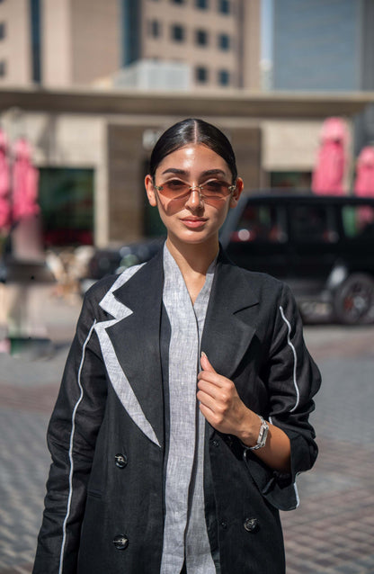Black blazer abaya with sharp lapels and white piping, combining tailored sophistication with modern street style.