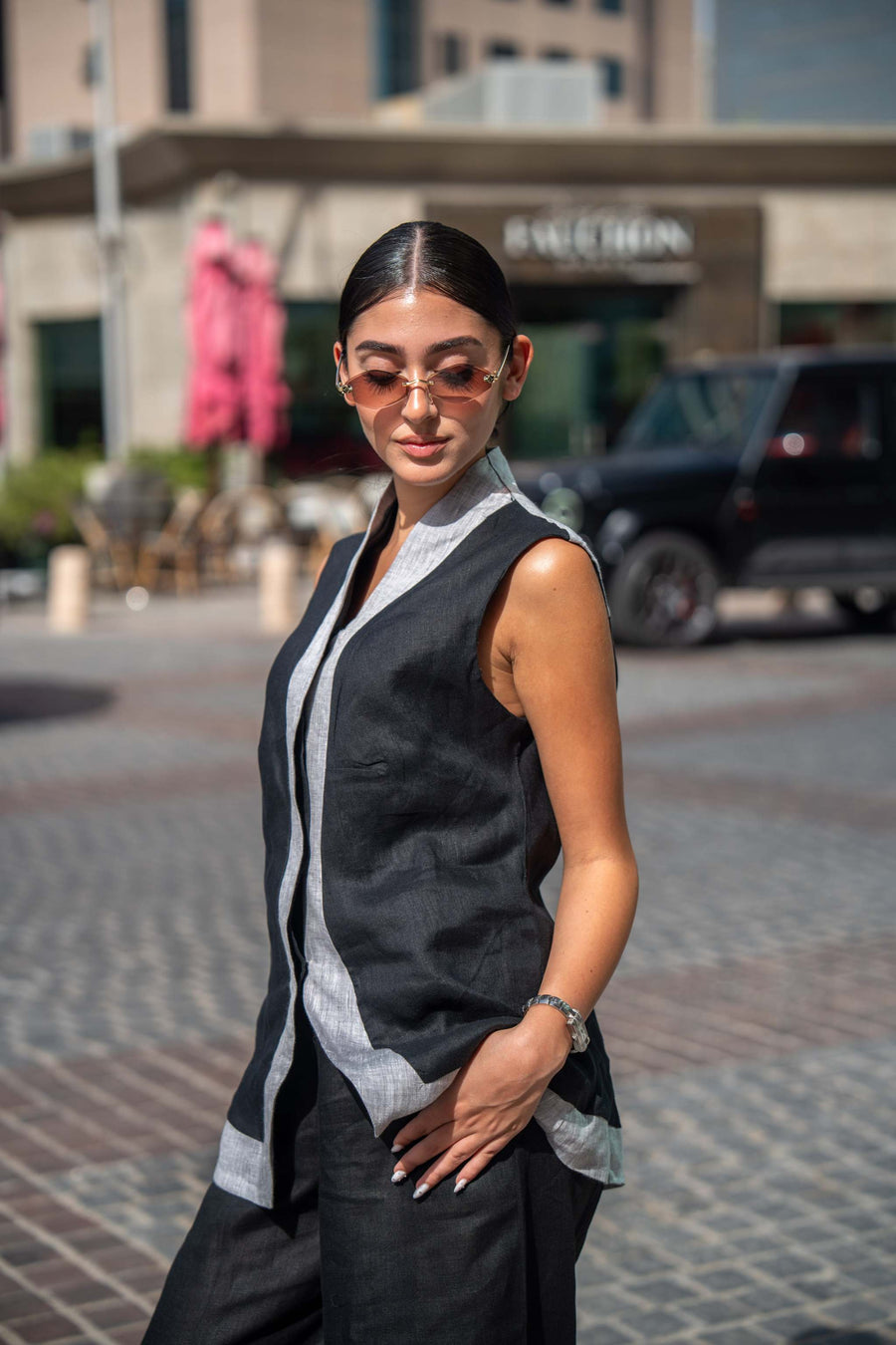 woman wearing black and gray sleeveless mist vest with sunglasses outdoors