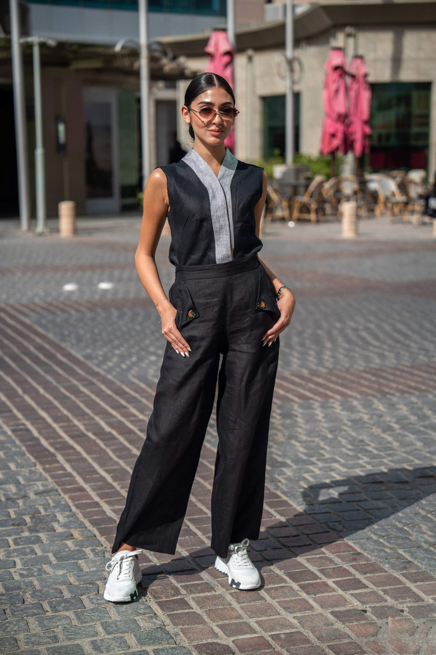 woman wearing black mist vest and matching wide-leg pants with white sneakers outdoors