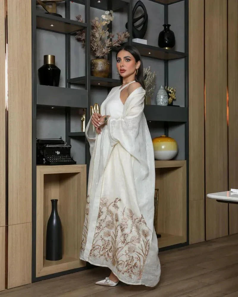 woman wearing white bisht daara set with gold hand embroidery standing indoors