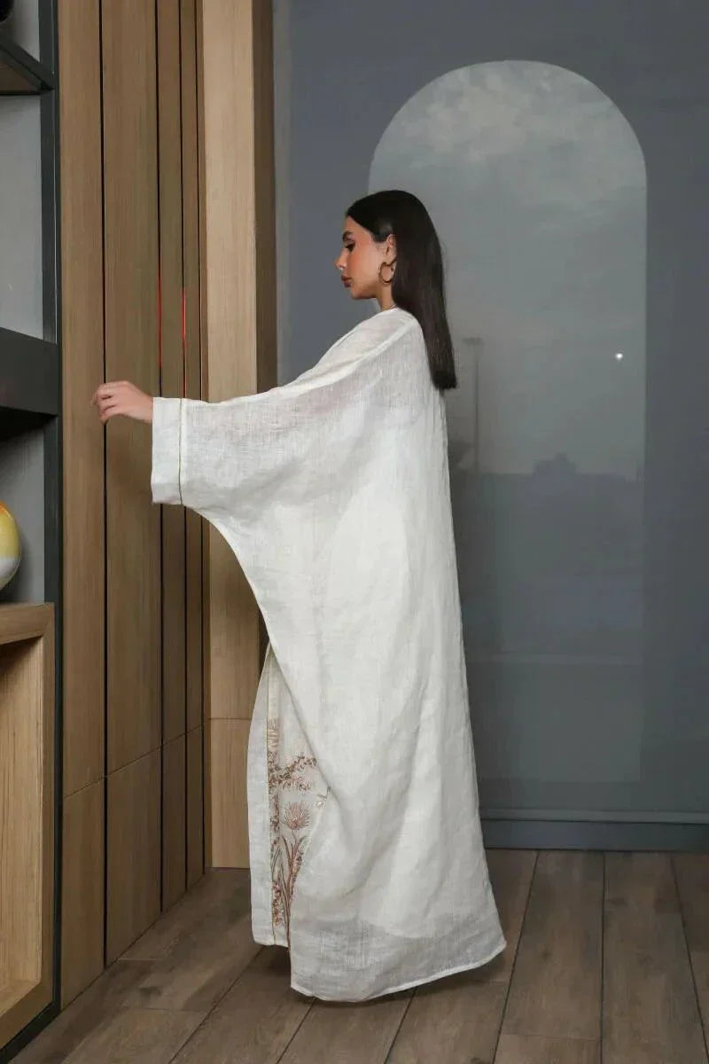 woman wearing white bisht daara set with gold hand embroidery standing indoors