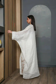 woman wearing white bisht daara set with gold hand embroidery standing indoors