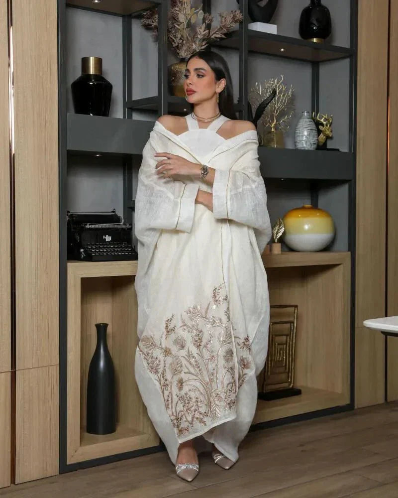 woman wearing white bisht daara set with gold hand embroidery standing indoors
