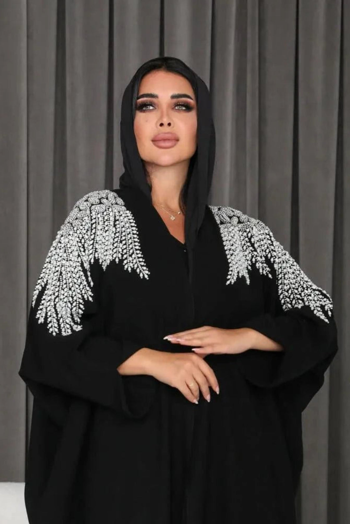Black abaya made of soft crepe fabric with delicate white and silver hand embroidery, featuring an elegant and versatile design.
