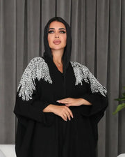 Black abaya made of soft crepe fabric with delicate white and silver hand embroidery, featuring an elegant and versatile design.