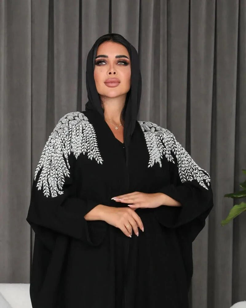 Black abaya made of soft crepe fabric with delicate white and silver hand embroidery, featuring an elegant and versatile design.
