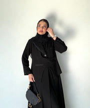 Elegant black abaya with button detailing and pocket accents in lightweight crepe fabric