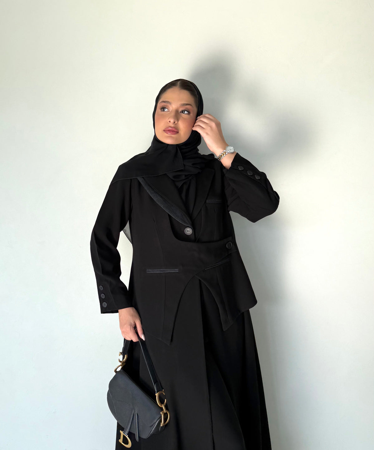 Elegant black abaya with button detailing and pocket accents in lightweight crepe fabric