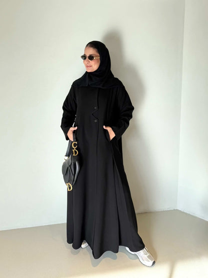 Black flowing crepe abaya with full button-down front, lightweight and elegant, styled with a black hijab and sunglasses.