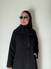 Black flowing crepe abaya with full button-down front, lightweight and elegant, styled with a black hijab and sunglasses.