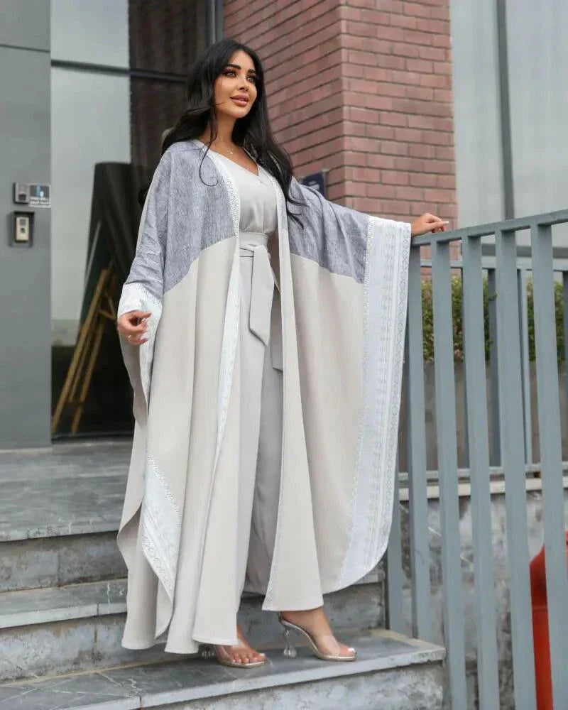 woman wearing light grey bisht with flowy and breathable fabric standing outdoors