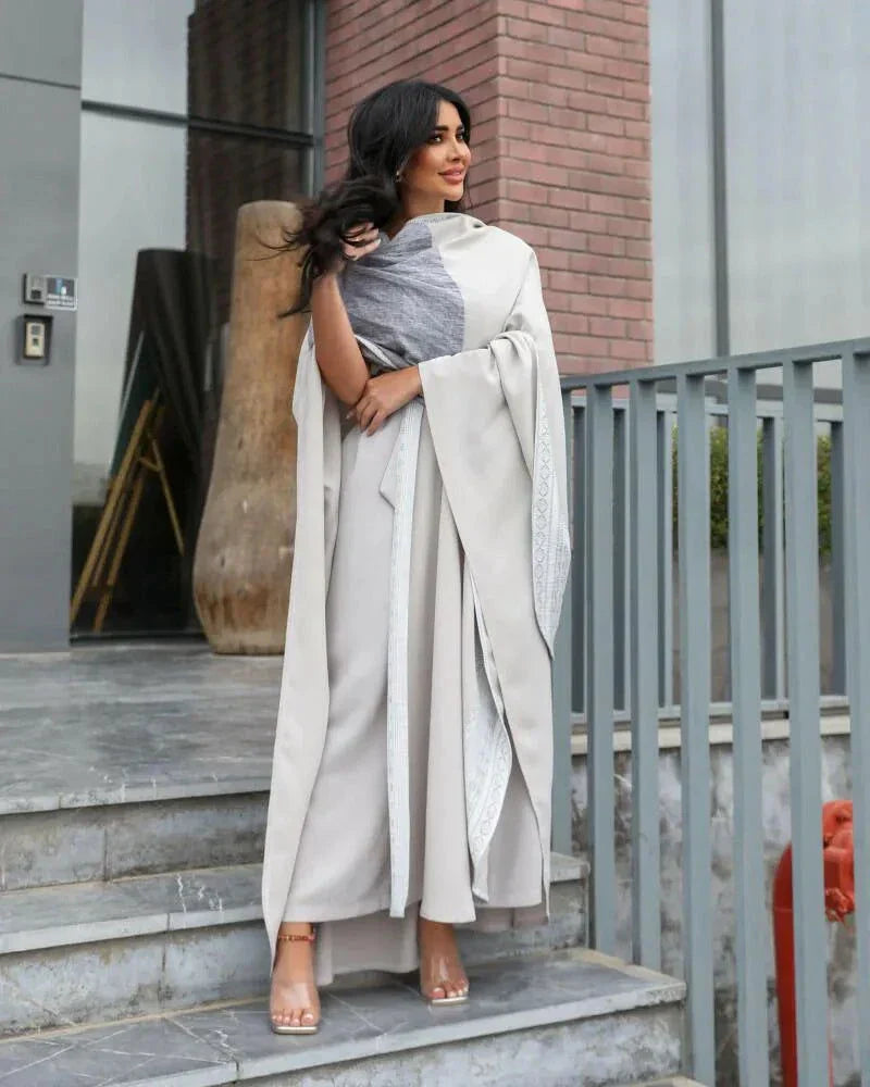 woman wearing light grey bisht with flowy and breathable fabric standing outdoors