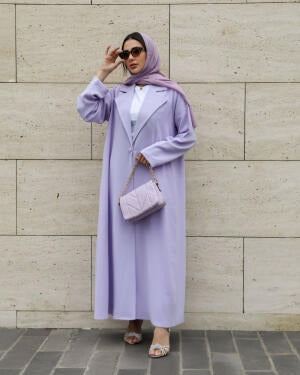 Woman wearing a soft lavender blazer-style abaya made from lightweight crepe fabric with a structured lapel and relaxed fit.