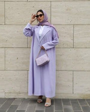 Woman wearing a soft lavender blazer-style abaya made from lightweight crepe fabric with a structured lapel and relaxed fit.
