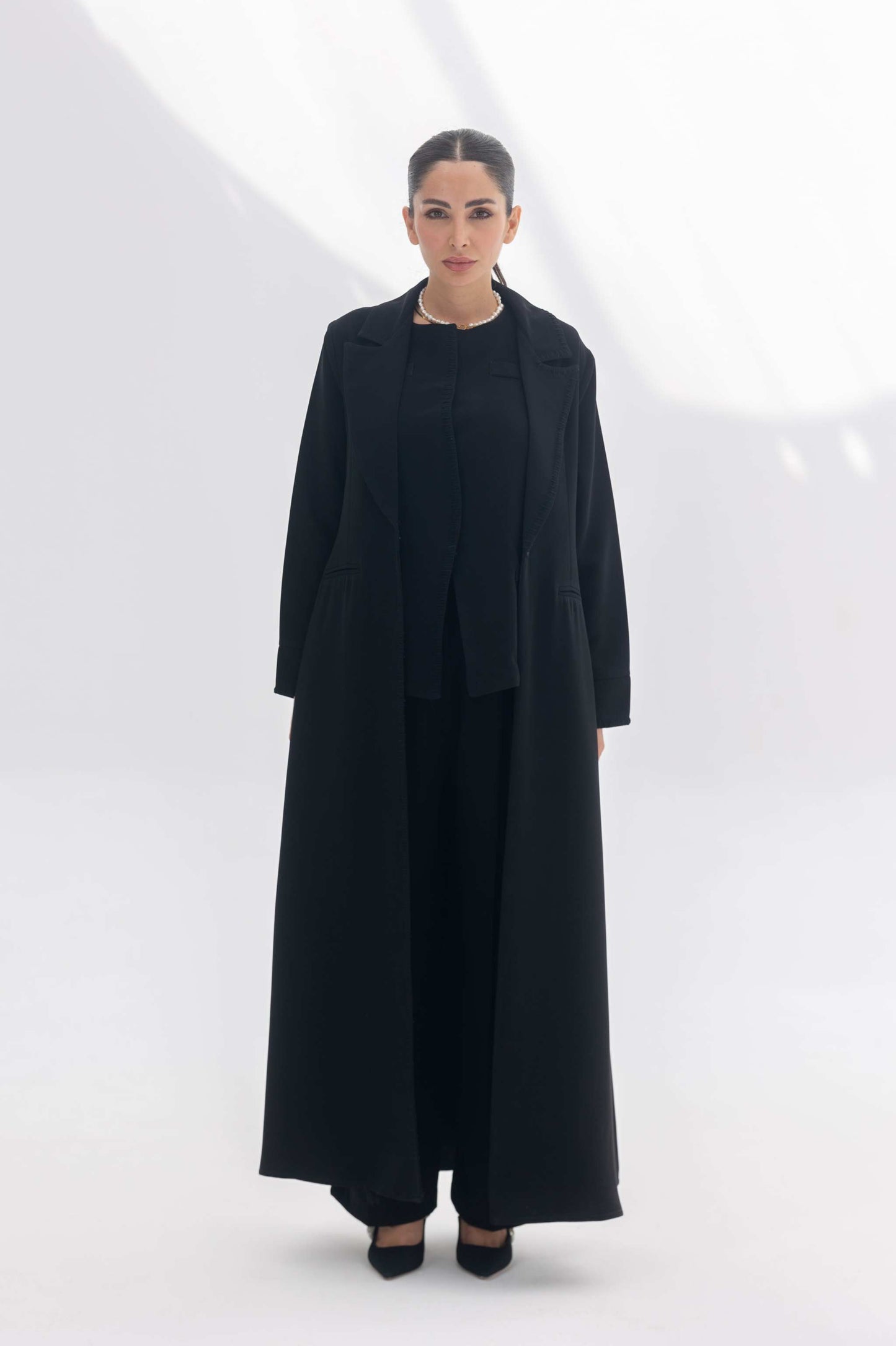 Black crepe blazer abaya with tailored silhouette and black embroidery, styled with matching inner and pants for a modern modest look.