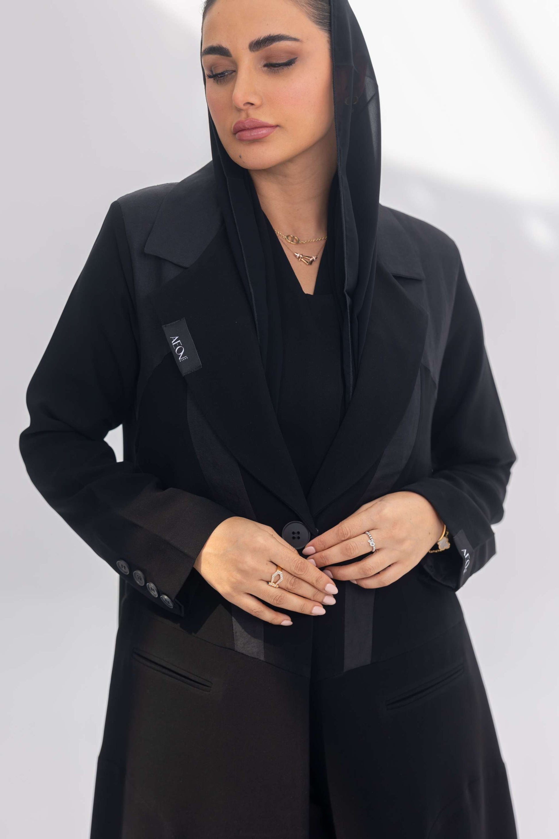 Woman wearing elegant black crepe Jetline abaya with dark grey accents and silk lining