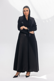 Woman wearing elegant black crepe front-open abaya with dark grey accents and silk lining, styled for modesty and comfort.
