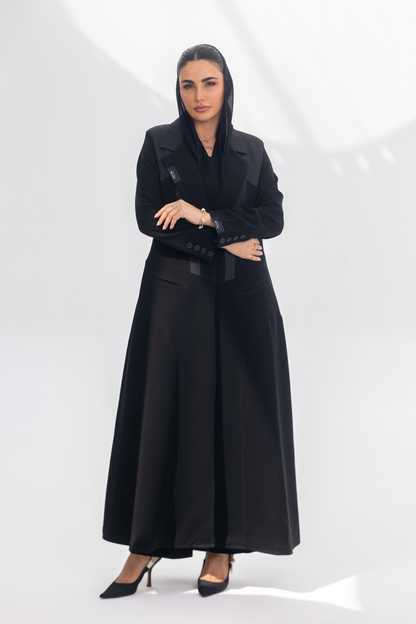 Woman wearing elegant black crepe front-open abaya with dark grey accents and silk lining, styled for modesty and comfort.