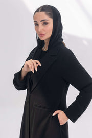 woman wearing a tailored black crepe blazer with a hooded inner, posing against a white background