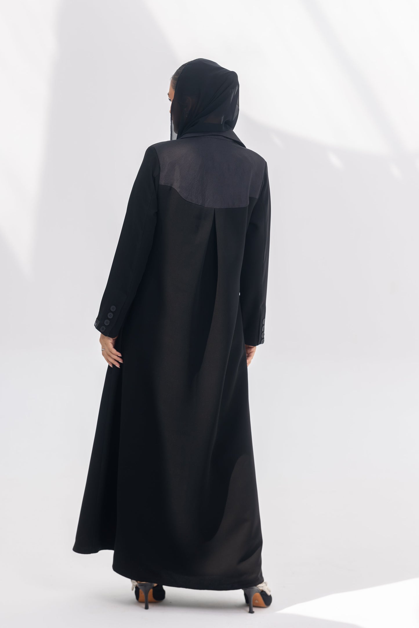Black crepe Jetline abaya with dark grey accents and silk lining, shown from the back.