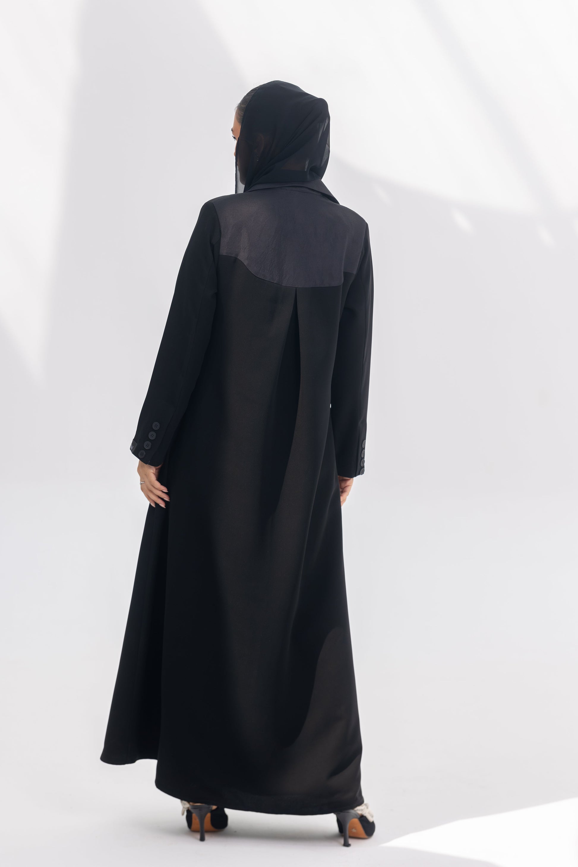 Black crepe Jetline abaya with dark grey accents and silk lining, shown from the back.