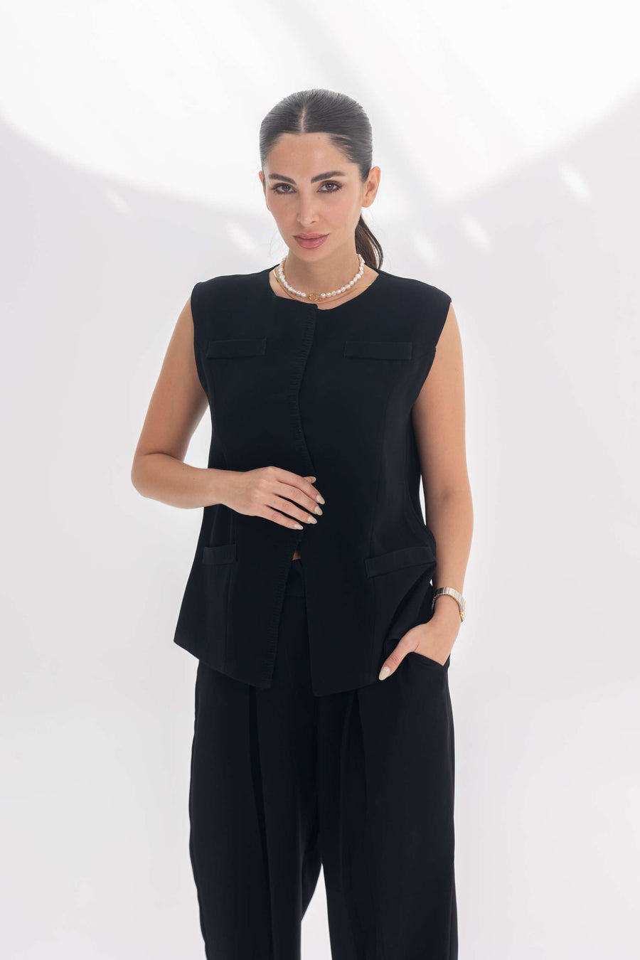 Woman wearing a black sleeveless crepe inner set with unique embroidery, styled for a sleek silhouette and refined elegance