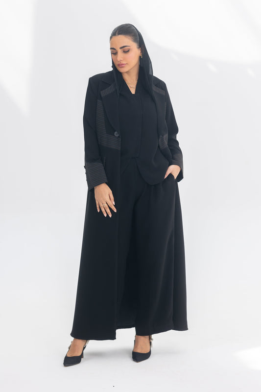 Woman wearing elegant black crepe blazer abaya with contrasting fabric and sleek silhouette.