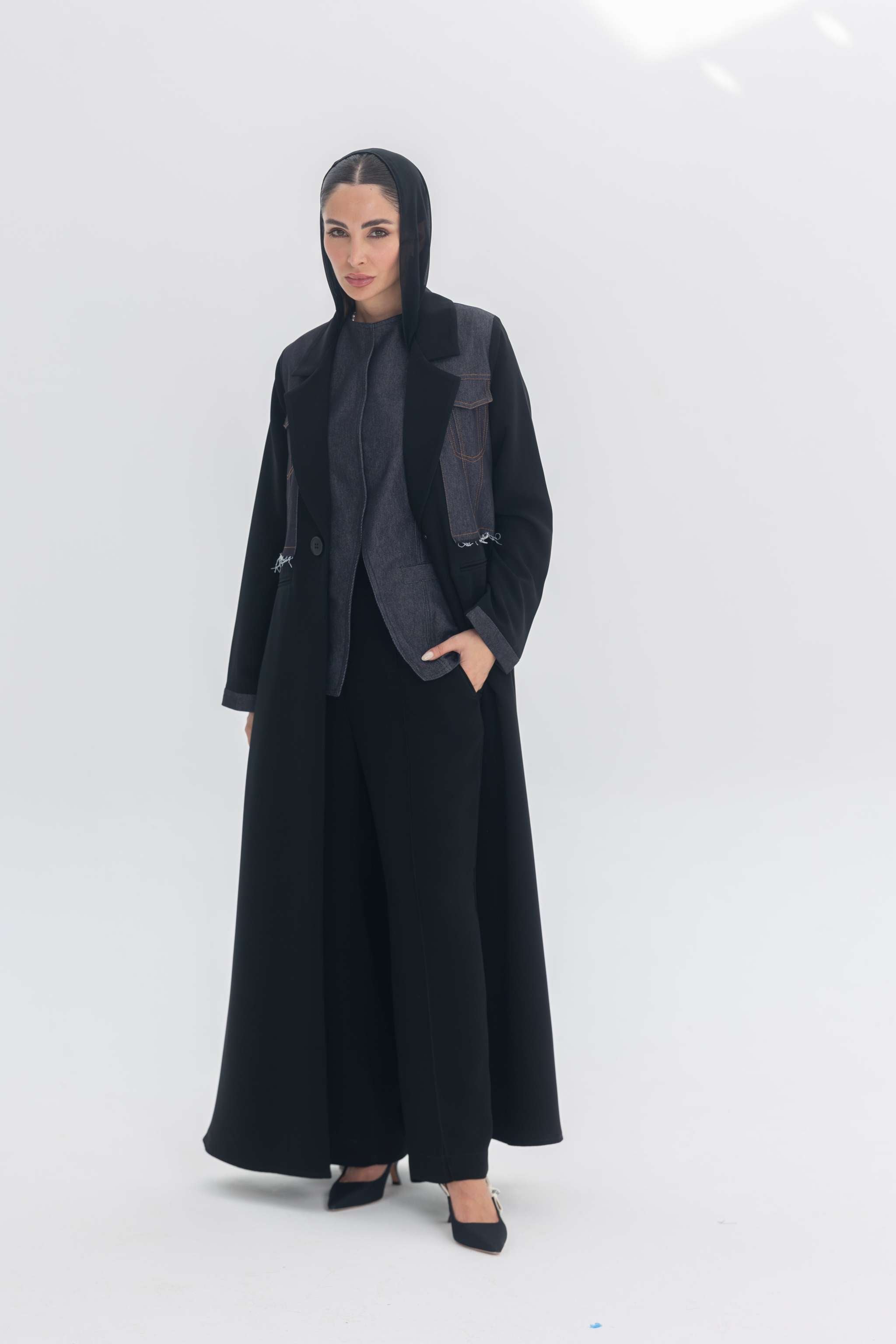 Woman wearing Denim Veil black crepe abaya with denim accents, blending modern edge and classic elegance.