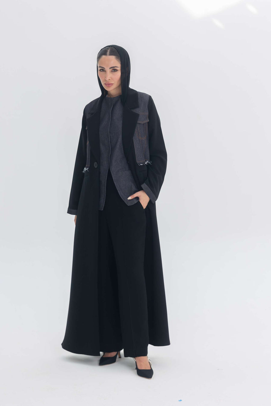 Woman wearing Denim Veil black crepe abaya with denim accents, blending modern edge and classic elegance.