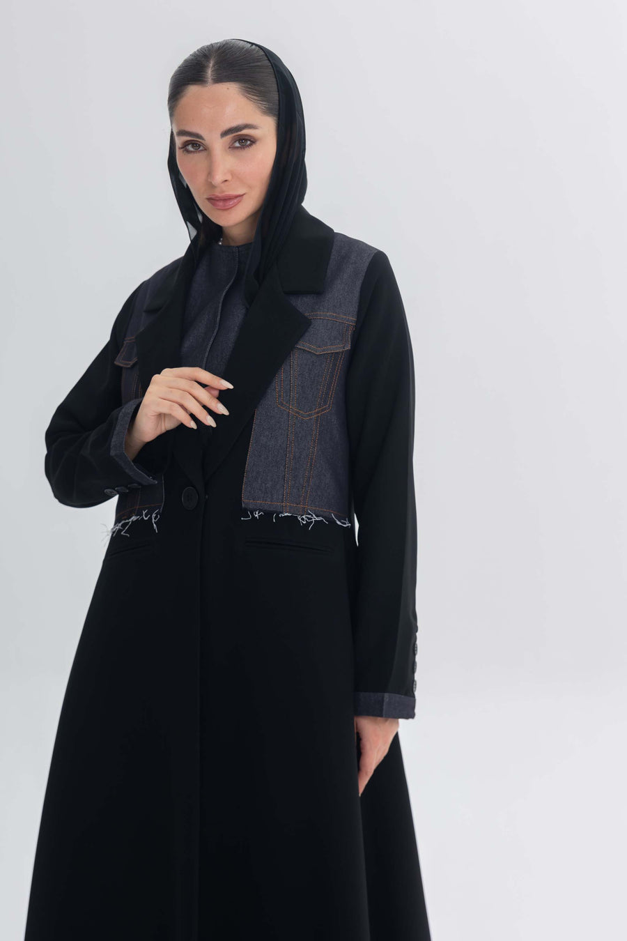 Woman wearing a black crepe abaya with distinctive denim accents and a black veil, styled for a modern and elegant look, Denim Veil fashion.